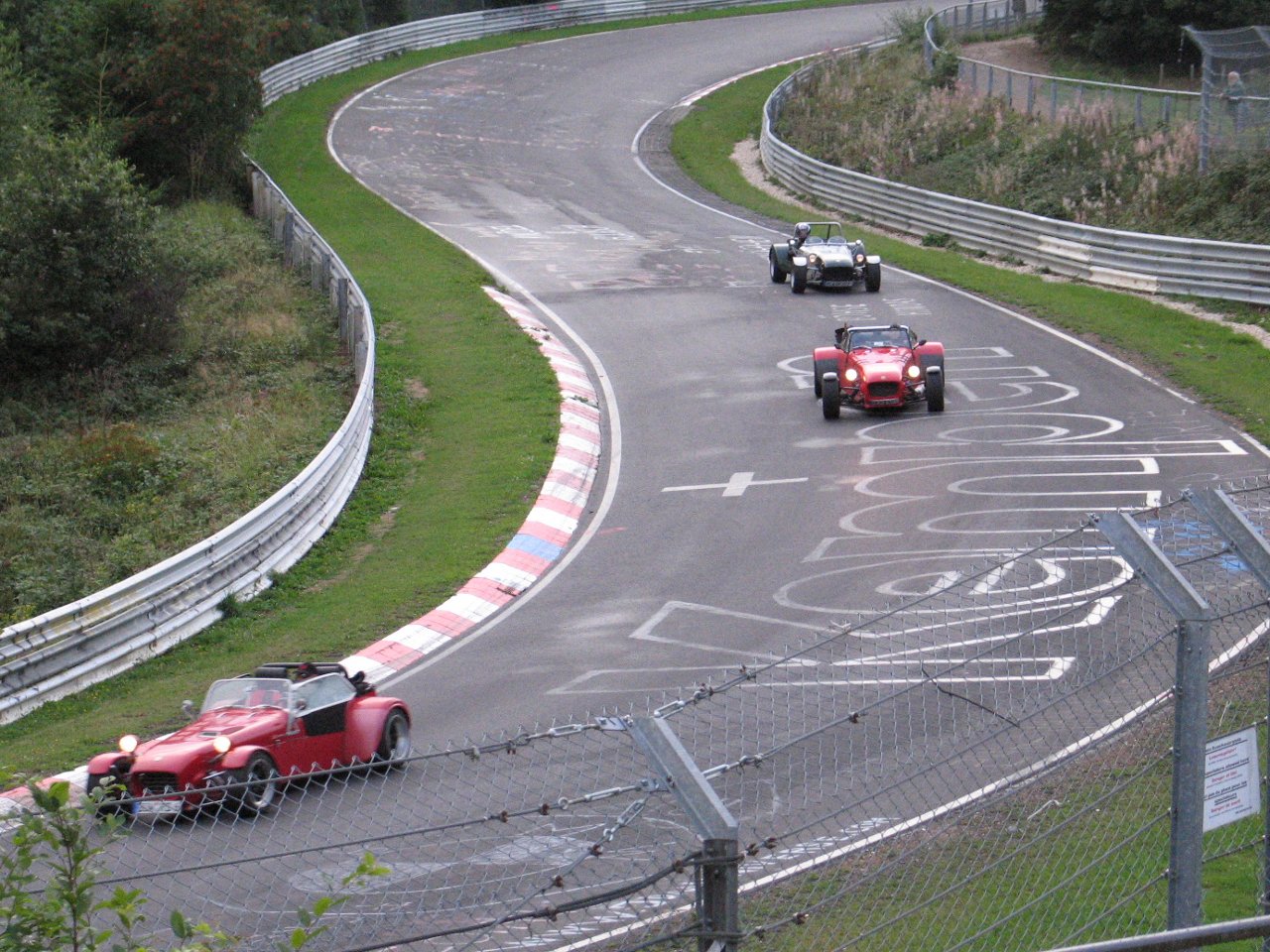 Some cars on a track with writing on it, yesterday